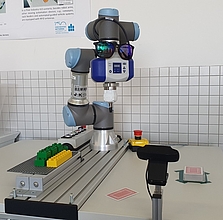 ein Roboter im Versuchsaufbau mit Legobausteinen und Spielkarten